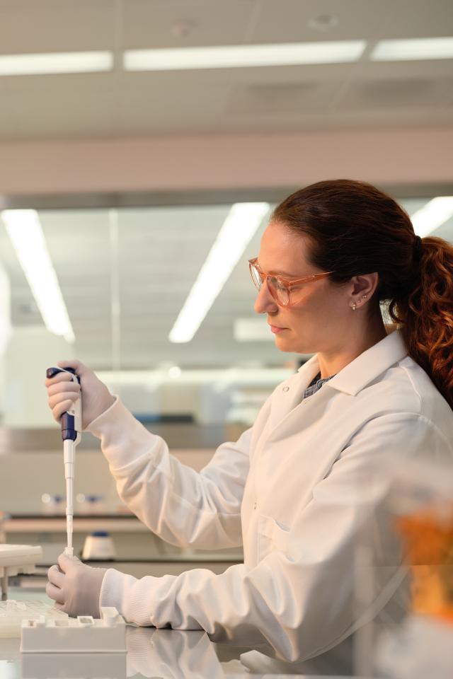 Scientist starting product pipetting into tube